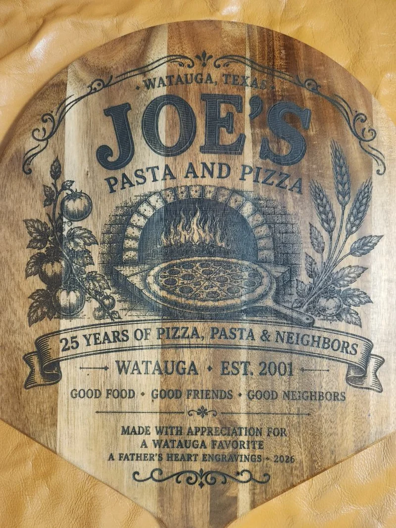 Full view of a custom wooden pizza peel engraved by A Father's Heart Engravings to celebrate 25 years of Joe's Pasta & Pizza serving the Watauga community.